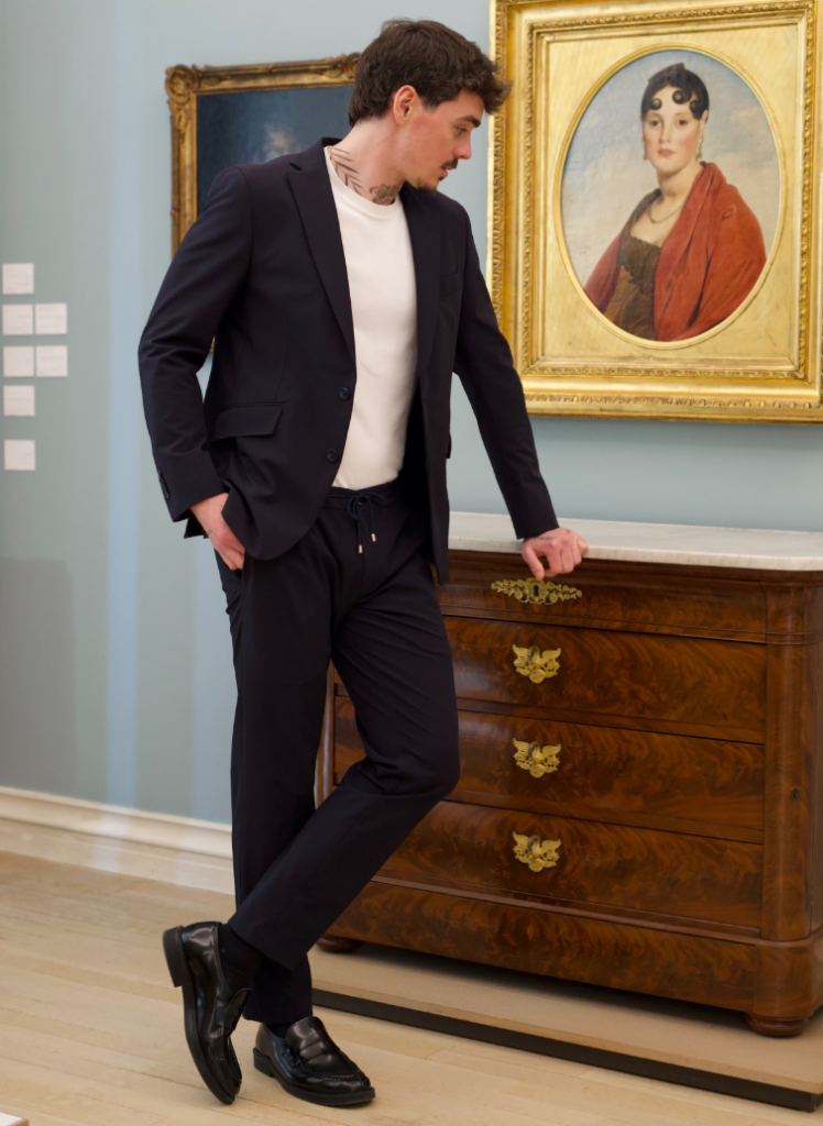 Homme portant un costume bleu nuit sur mesure avec t-shirt blanc et pantalon coordonné.