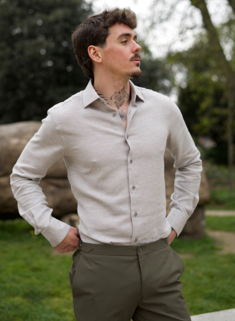 Homme portant une chemise beige clair sur mesure avec pantalon kaki habillé.